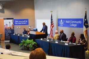 USDA-RD NC State Director, Reginald Speight speaking while standing beside event panel 